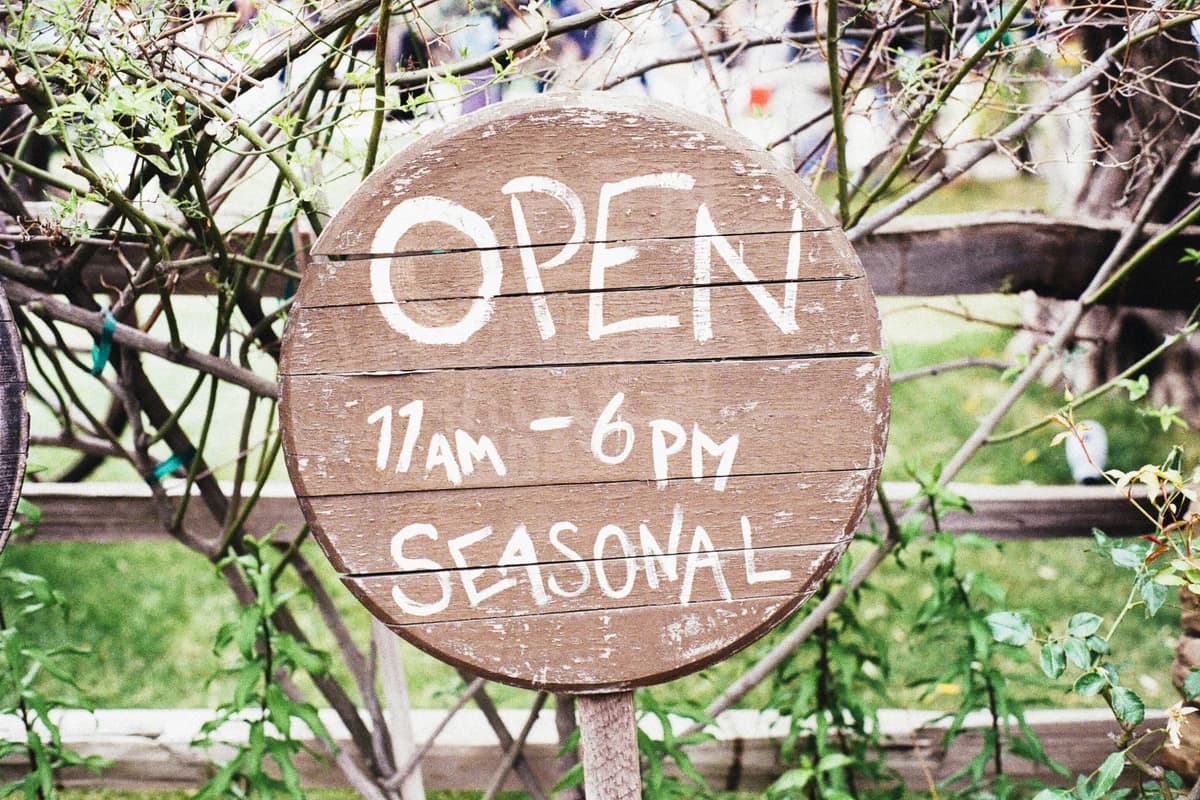 Before the edit, a real round wooden sign reads “OPEN”
